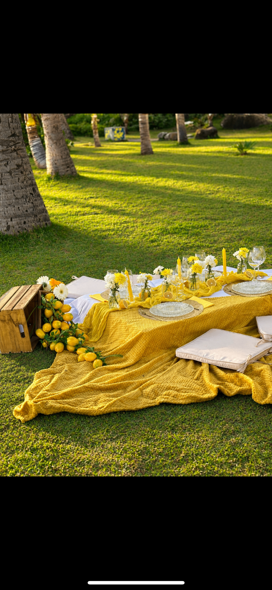 Picnic premium jaune citron sur l'herbe avec décoration florale et bougies au coucher du soleil