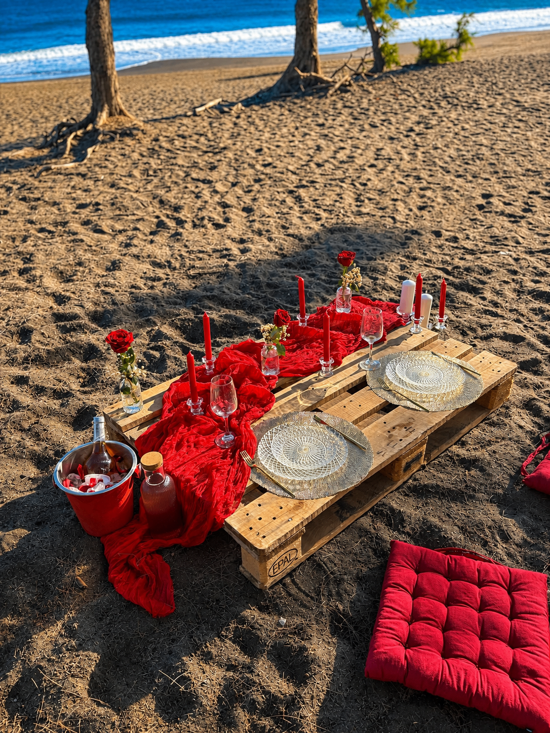 Table anniversaire ou surprise sur la plage avec décoration rouge